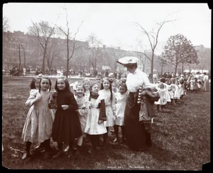 Děti v dlouhé řadě vedená ženou na Arbor Day v Tompkins Square Park, New York, 1904 (stříbrný želatinový potisk)